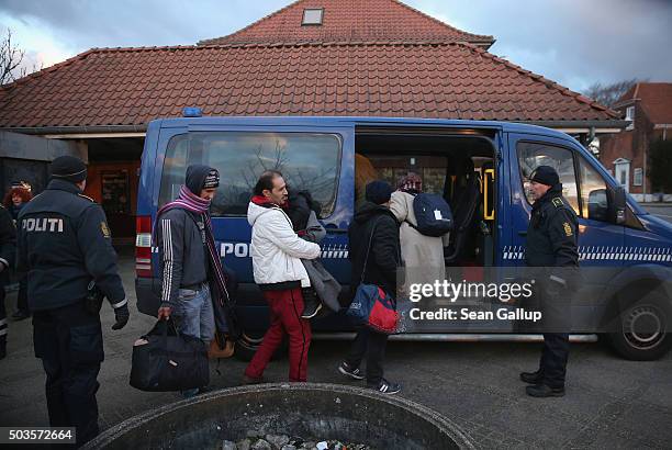 Danish police escort a family from Syria seeking asylum in Denmark after finding them while checking the identity papers of passengers on a train...