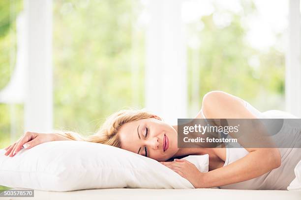 woman sleeping in bed - bed side view stock pictures, royalty-free photos & images