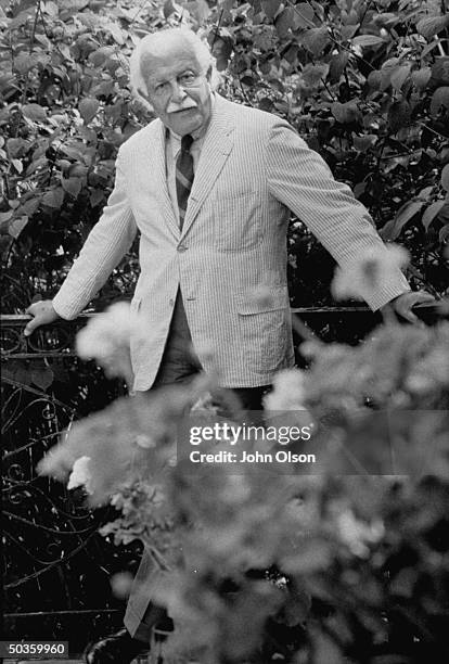 Boston Pops conductor Arthur M. Fiedler standing in his garden.