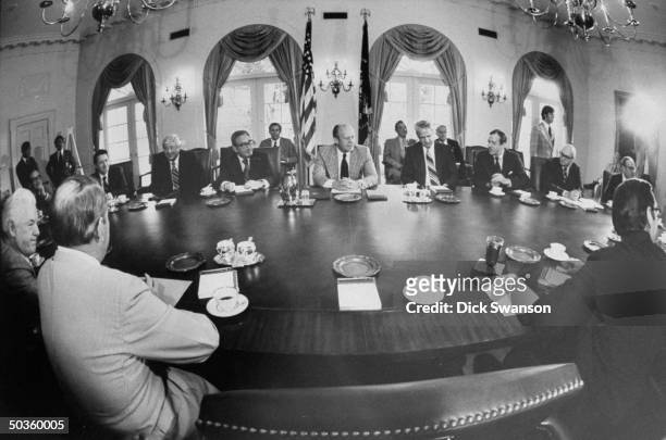 President Gerald R. Ford sitting with Secretary of State Henry A. Kissinger during Ford's first cabinet meeting.