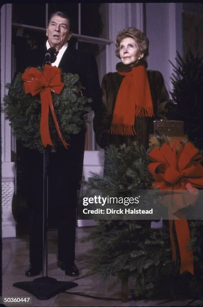 President Ronald W. Reagan , with his wife Nancy , speaking at a wreath adorned mike, during the lighting of the National Christmas tree for the last...