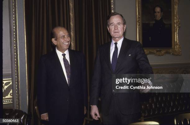 Vice President/President Elect George H. W. Bush , smiling, standing with Venezuelan President elect Carlos Andres Perez .