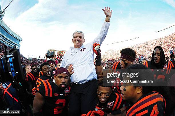 Head Coach Frank Beamer of the Virginia Tech Hokies is carried off the field by Donovan Riley and J. C. Coleman after the game against the North...