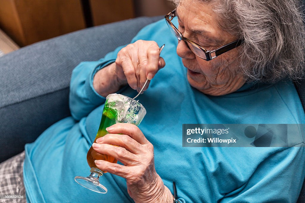 Mulher Idosa a comer Semi-Frio com Natas Batidas Gelatina