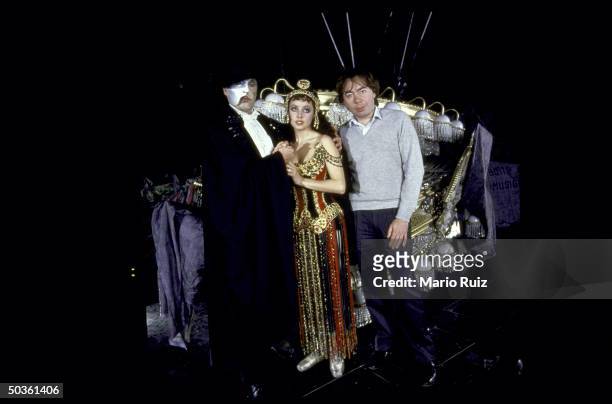Composer Andrew Lloyd Webber posing with actress/wife Sarah Brightman and actor Michael Crawford, both in costume, during rehearsal for Webber...
