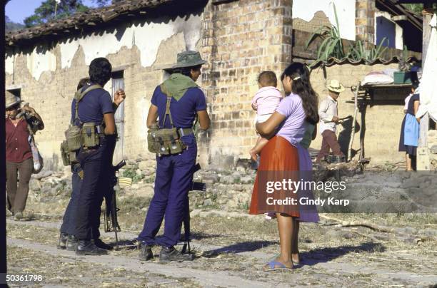 Rebel guerrillas talking with villagers who have recently returned home from Honduran refugee camps.