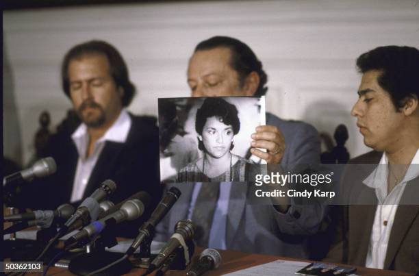 Culture Minister Julio Adolfo Rey Prendes holding a picture of President Duarte's daughter, Ines Duarte Duran, at a press conference, concerning her...