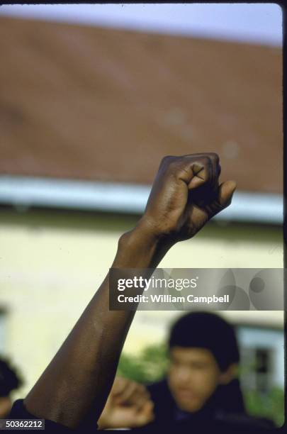 Black protestor raises clenched fist during anti-apartheid demonstrations.