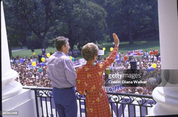 President Ronald W. Reagan with wife Nancy greeting supporters on his return to White House after colon cancer surgery.