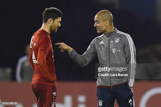Head coach Josep Guardiola gives instructions to Xabi Alonso during a training session at day one of the Bayern Muenchen training camp at Aspire...