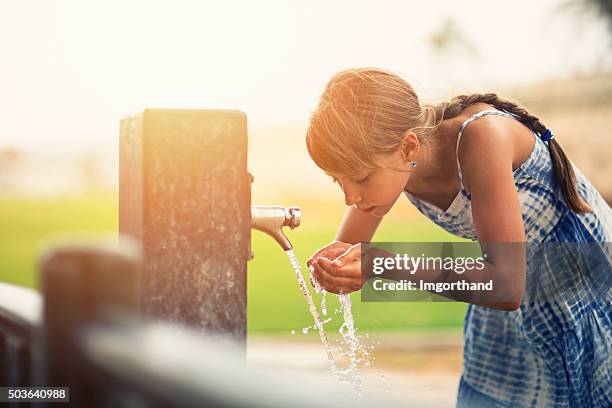little girl drinking water - tap stockfoto's en -beelden