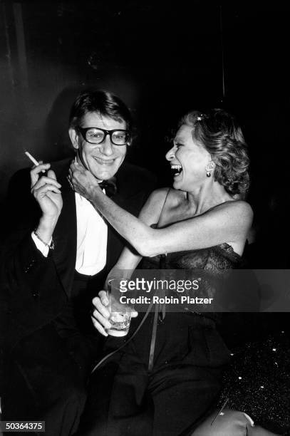 Designer Yves Saint Laurent w. Socialite Nan Kempner during party for the launching his new perfume called Opium, held aboard the sailboat Peking at...