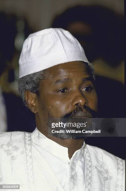 President of Chad Hissene Habre wearing a white embroidered hat & robe at an OAU meeting.