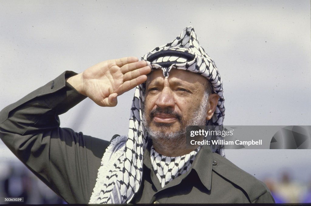 PLO Leader Yasser Arafat Saluting Upon Arriving For The OAU Meeting palestine-middle-east-people-politicians-plo-leader-yasser-arafat-stock