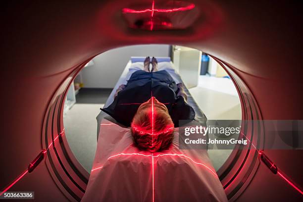 patient lying inside a medical scanner in hospital - cat scan machine stock pictures, royalty-free photos & images