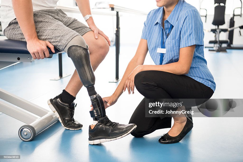 Medical professional ayuda hombre con una pierna ortopédica