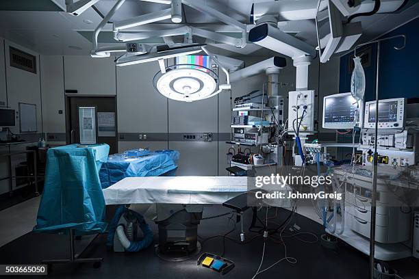 bloco operatório com cama e equipamentos médicos em branco - sala de cirurgia com assistência imagens e fotografias de stock