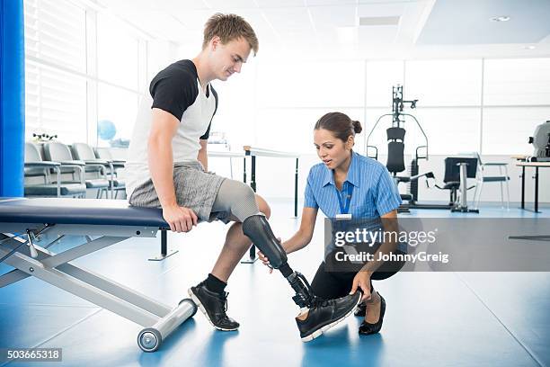 physiothérapeute jeune homme aidant femme avec des jambes artificielles. - amputé photos et images de collection