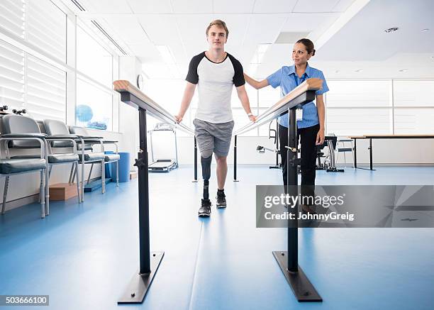 man with prosthetic leg using parallel bars with physyiotherapist - physiotherapist bildbanksfoton och bilder