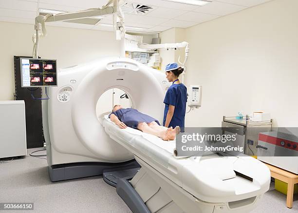 radiologue regardant un patient dans un scanner à l'hôpital de chat - tomographie par émission de positrons photos et images de collection