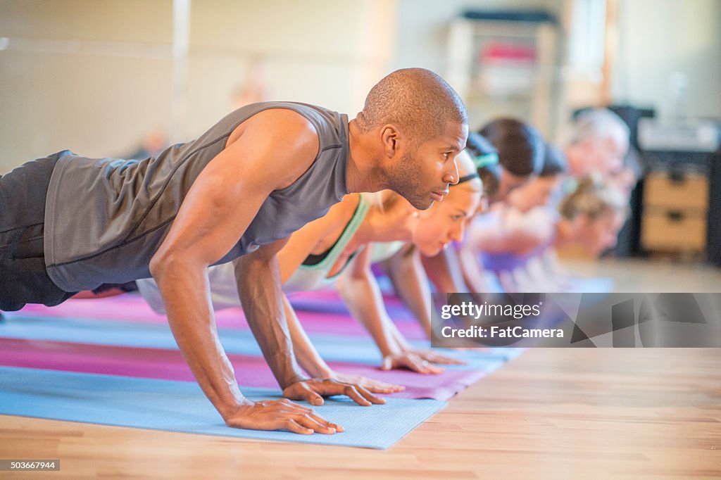 Tenant la position de planche, en cours de Yoga