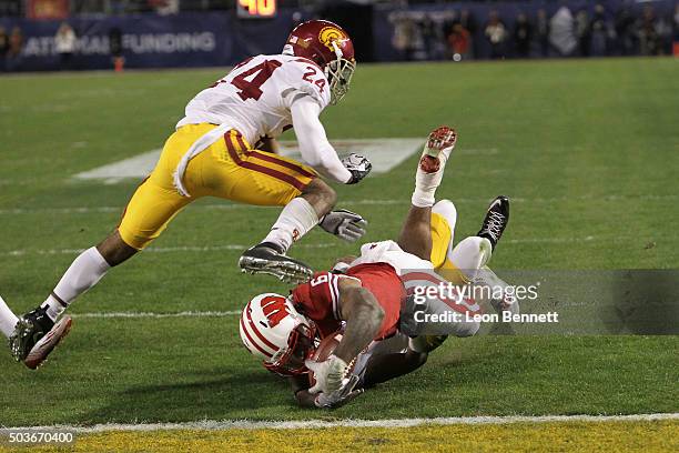 Vince Biegle and Adoree' Jackson of the USC Trojans tackle Corey Clement of the Wisconsin Badgers during the National University Holiday Bowl at...