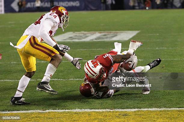 Vince Biegle and Adoree' Jackson of the USC Trojans tackle Corey Clement of the Wisconsin Badgers during the National University Holiday Bowl at...