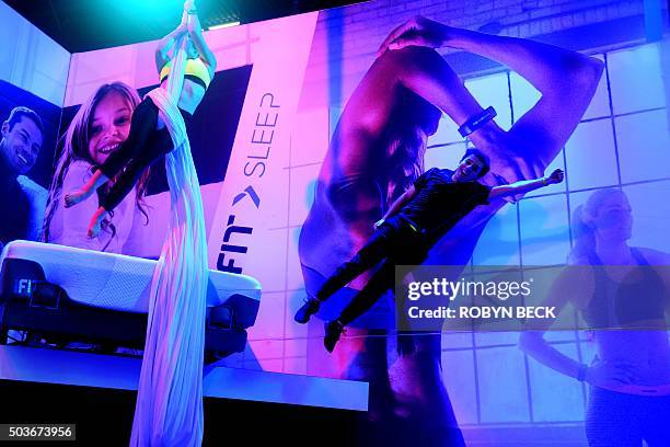 Dancers wearing iFit monitors fly through the air in a performance at the iFit booth, January 6, 2016 on the first day of the CES 2016 Consumer...