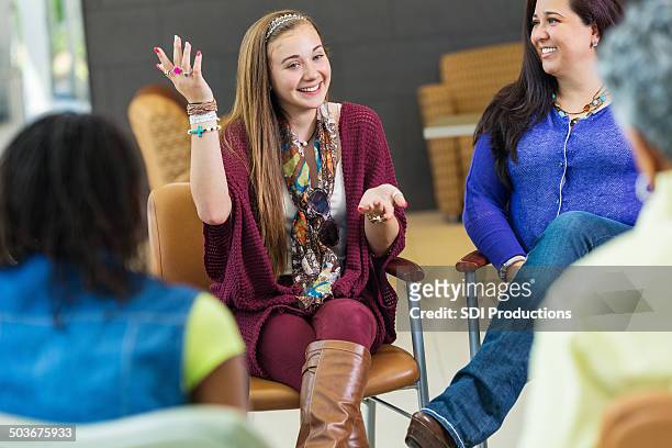 happy teen girl talking at therapy support group meeting - teen group therapy stock pictures, royalty-free photos & images