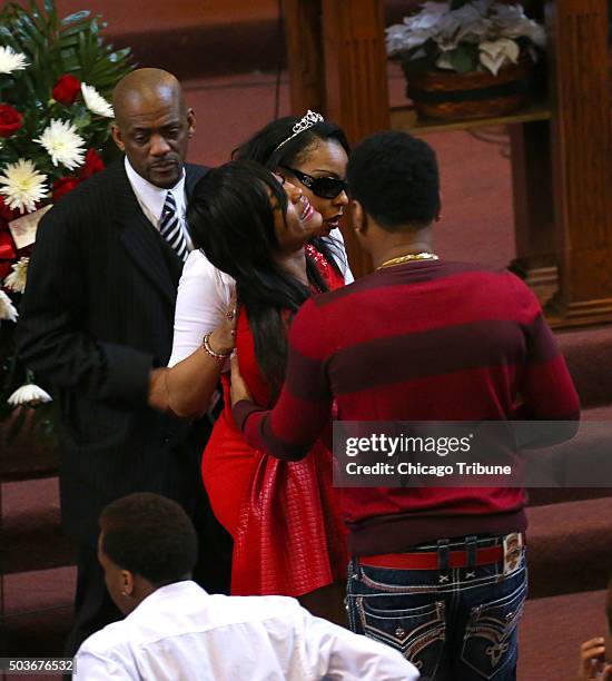 LaToya Jones, top middle, helps her distraught sister, LaTonya Jones, back to her seat after viewing her mother, Bettie Jones, in her casket during...