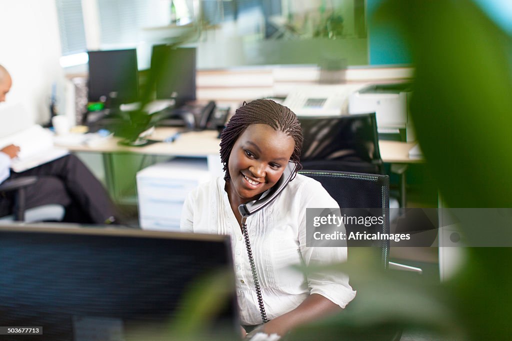 African business women smiling, having a telephone conversation