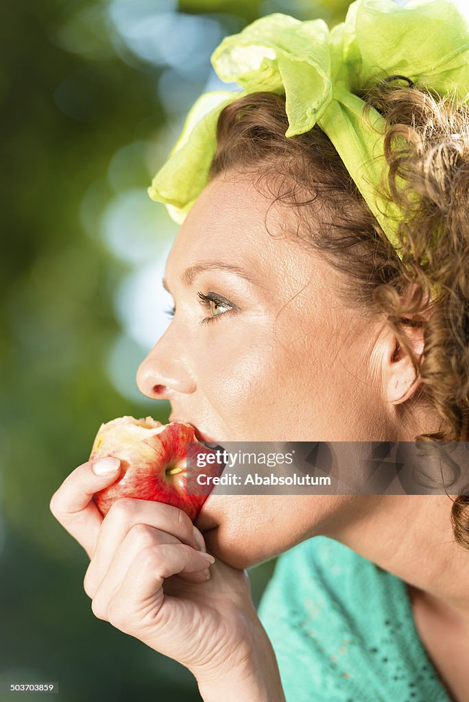 Portrait of Mature Woman Eating Apple, City Park, Italy, Europe