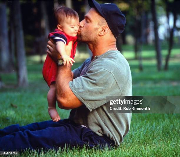 Feature. Buffalo Bills Chris Spielman, casual, kissing son Noah.