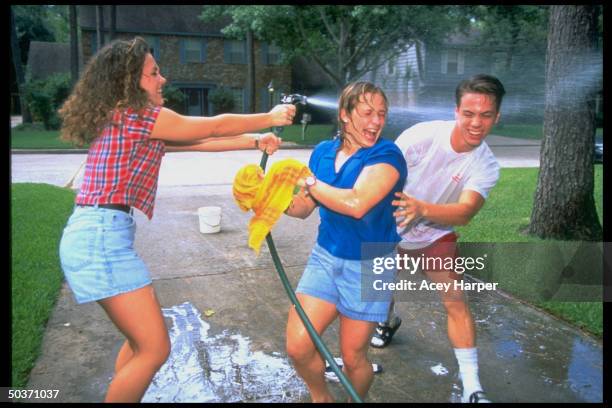 Former Olympic gymnast Kim Zmeskal & boyfriend Chris Burdette getting sprayed w. Garden hose by sister Melissain driveway at home.