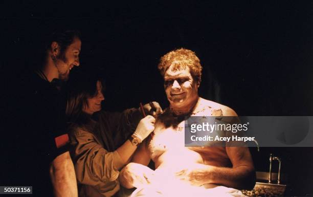 Unident. Special effects artists placing fake rotted skin on the chest of unident. Actor on the set of cult TV series The X-Files.