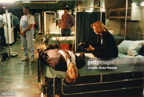 Gillian Anderson & David Duchovny, co-stars of cult hit TV series The X-Files, relaxing on bed in between filming on the set of the show.