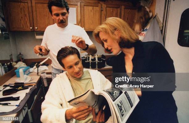 David Duchovny & Gillian Anderson, co-stars of cult hit TV series The X-Files, chatting as Duchovny gets hair done by stylist Robert Pandini in...