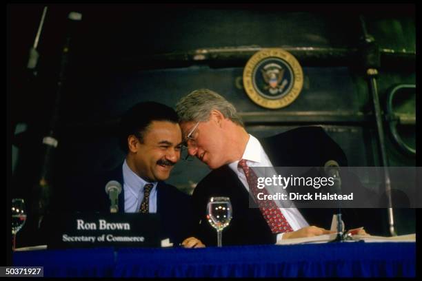 Commerce Secy. Ron Brown smiling at Pres. Bill Clinton's comment, latter wry-faced, resting his head against former's, during mtg. On economy at...