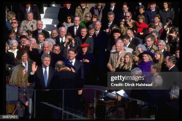 Pres. Bill Clinton raising hand, taking oath of office in his Inaugural Day swear-in, wife Hillary Rodham Clinton, daughter Chelsea, VP Gore & family...