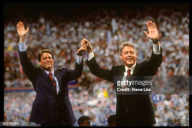 Pres. & VP nominee Bill Clinton & Al Gore raising clasped hands victoriously, waving w. Their free arms to crowd on floor of Democratic Convention at...