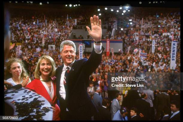 Pres-nominee Bill Clinton waving to crowd on floor of Democratic Natl. Convention, wife Hillary Rodham Clinton & daughter Chelsea by his side.