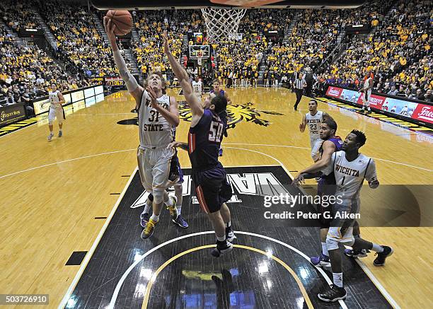 Guard Ron Baker of the Wichita State Shockers drives in for a basket against forward Blake Simmons of the Evansville Aces during the second half on...