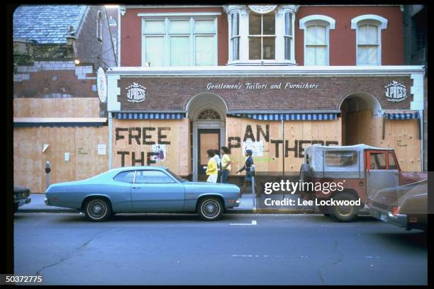 Writing on boarded-up store fronts reading FREE THE PANTHERS.