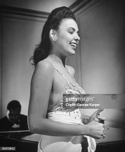 Singer Lena Horne singing Cole Porter's Let's Do It w/o a microphone in front of rapt guests in Savoy-Plaza Hotel's Cafe Lounge.