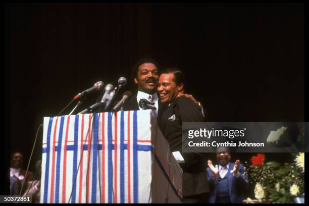 Democratic presidential primary hopeful Jesse Jackson embracing Nation of Islam leader Louis Farrakhan during campaign rally.