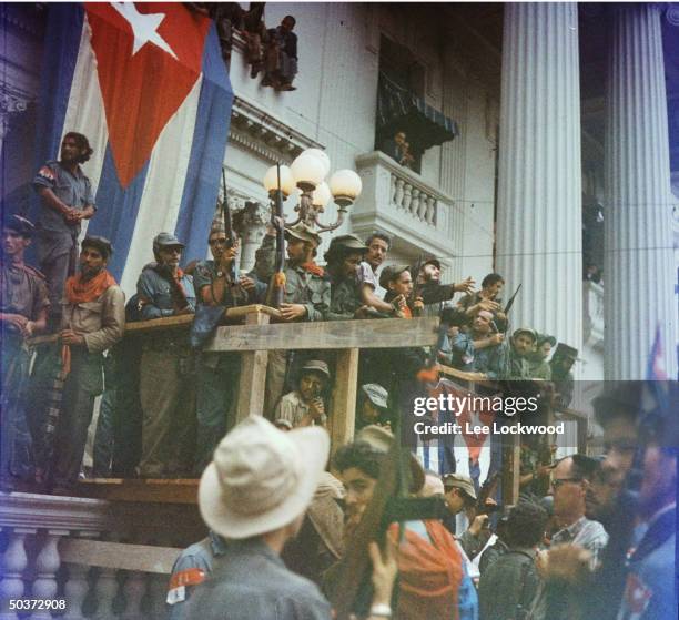 Fidel Castro in Santa Clara orating from makeshift balcony draped w. Cuban flags in Santa Clara en route to victorious entry into Havana.