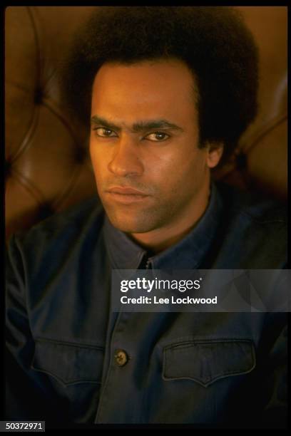 Activist Huey P. Newton, with Afro haircut, in his penthouse living room.