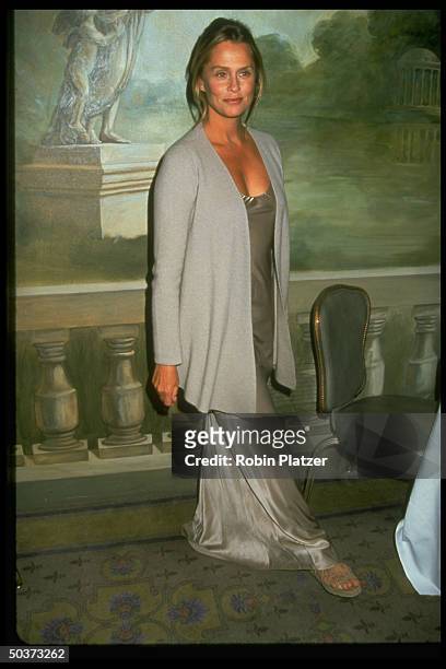 Actress/model Lauren Hutton wearing long pearl colored silk dress and taupe cardigan, both designed by Calvin Klein.