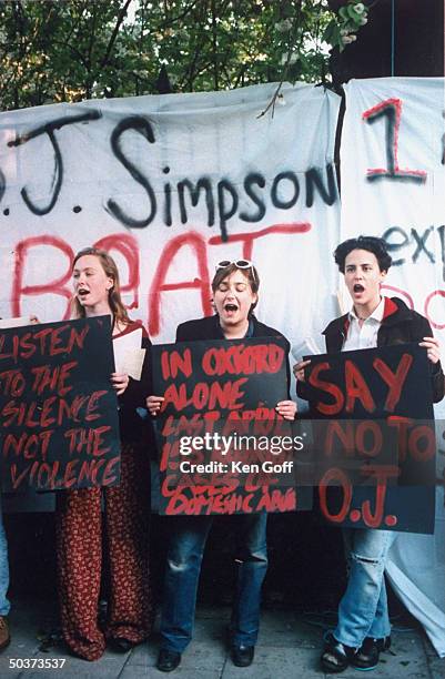 Protesters holding up signs emblazoned w. SAY NO TO O.J. Outside Oxford Union Society's debating hall, re visit of football hero/actor O.J. Simpson,...