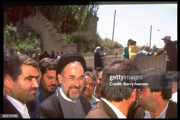 Moderate cleric presidential candidate Mohammed Khatami , surprise front-runner, in crowd of supporters outside polling station on election day.